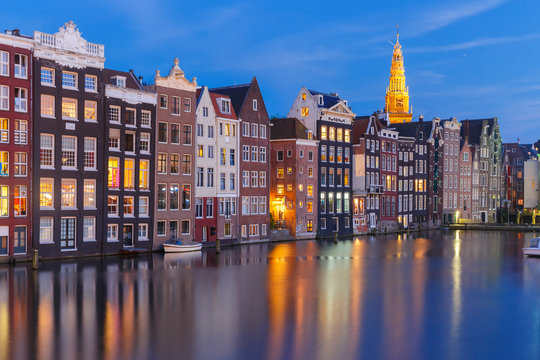Amsterdam canal with typical houses and church during twilight blue hour, Holland, Netherlands