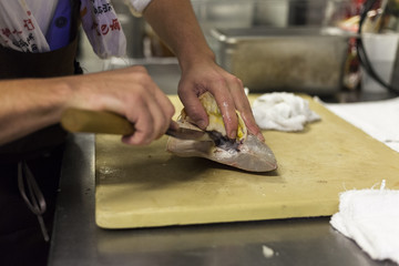 Fototapeta na wymiar A chef fillets fish before service. 