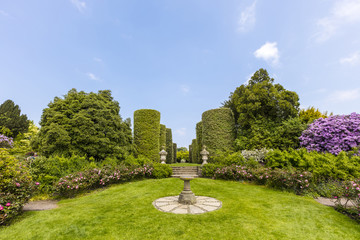 English garden with rose border and an old sundial.