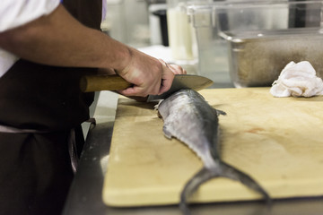 A chef fillets fish before service. 