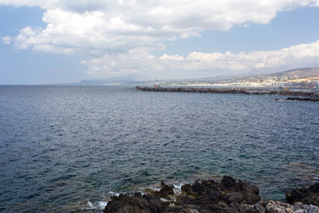 Stone pier stretching into the sea on the background of the old
