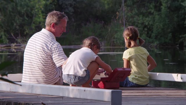 Father with son and daughter on fishing dock