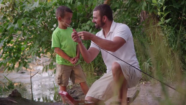 Father teaching son how to bait and fish