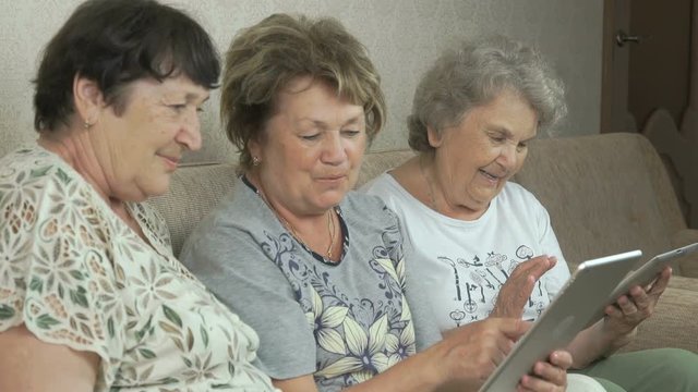 Old women holding the digital tablets