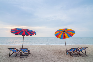 Beach chairs with umbrella and beautiful beach on a cloudy da