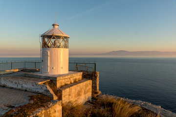 Fototapeta na wymiar Sunset over Lighthouse in Kavala and Thassos island in background, East Macedonia and Thrace, Greece