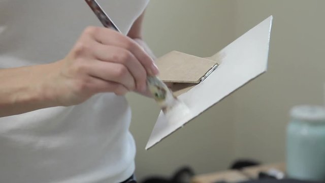 Girl paints a paint box of handmade