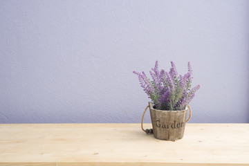 Fototapeta premium Wood table with purple lavender flower on flower pot and purple