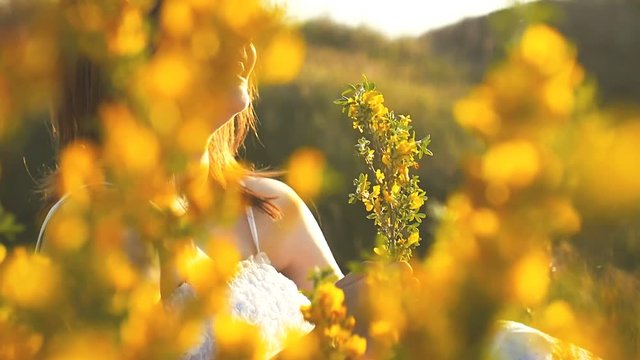 the girl laughs and sniffs flowers slow motion video