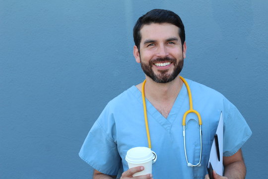 Portrait Of Friendly Male Doctor Smiling Holding A To Go Cup Of Coffee And A Folder With Documents 