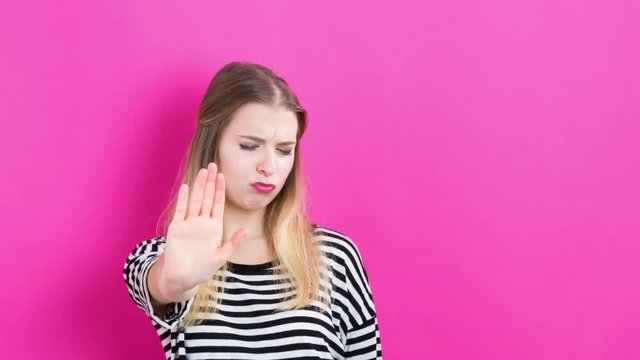 Time-lapse of a young woman doing a variety of poses on on vibrant pink background