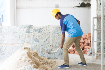 indian male contractor using shovel