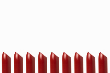 Rows of red lipstick on a white background.