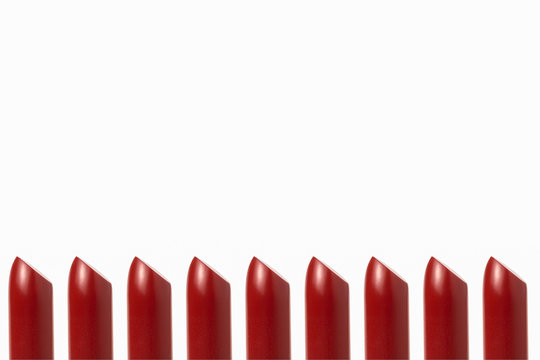 Rows of red lipstick on a white background.