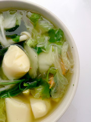 Clear Soup with Bean Curd , mix vegetable, Tofu and seaweed in white bowl on white background. Vegetarian Food, Healthy food, Thai food