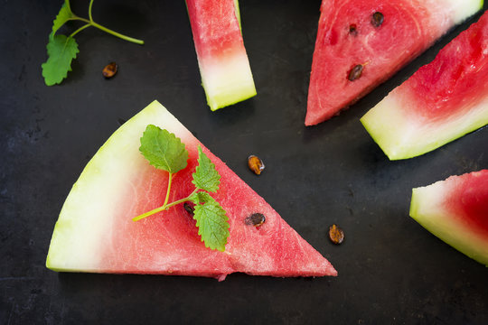 Slices of watermelon on a black background, top view