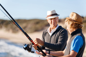 Senior man fishing with his grandson