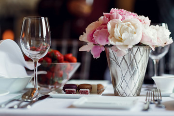 Glass, snack and flowers on a table at breakfast