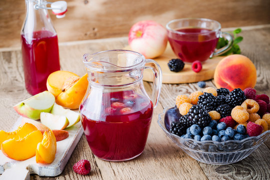 Fresh summer berries and fruits in  glass bowl on wooden rustic