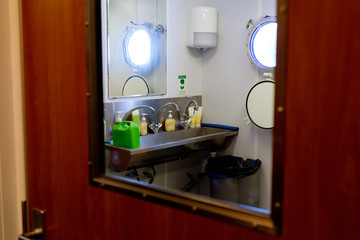 Bathroom on a ship taken through the window of the bathroom door.