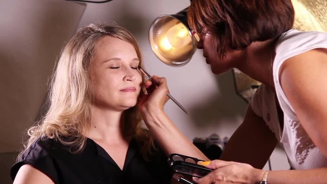 Makeup artist makes models eye makeup
