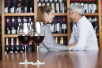 Red Wine In Glasses With Couple In Background