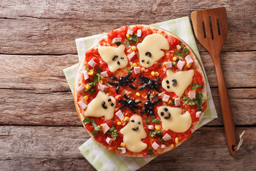 Halloween Food: Pizza with ghosts and spiders close-up. horizontal top view
