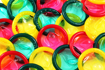 A close up image of a multitude of colored condoms - obrazy, fototapety, plakaty