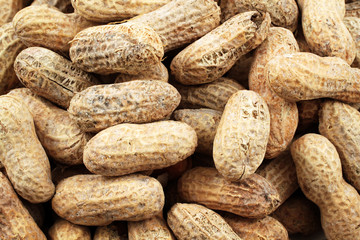 A close up image of whole peanuts in the shell