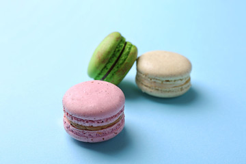 Tasty colorful macaroons on light blue background