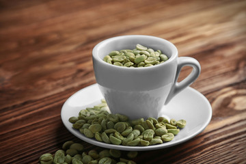 Fototapeta na wymiar Cup of coffee with grains on table
