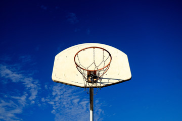 basketball hoop and backboard against blue sky