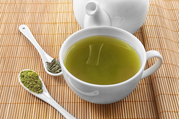 Fresh matcha tea on mat background