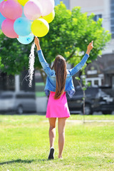 Beautiful girl with balloons on street