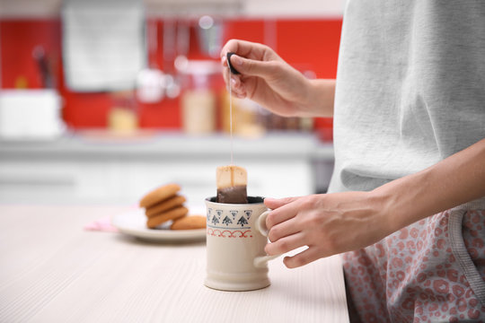 Breakfast concept. Woman holding cup of tea in kitchen