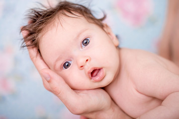 Portrait of a newborn baby girl on a light background