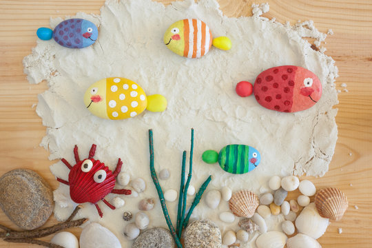 Painted stone fishes on the sand craft