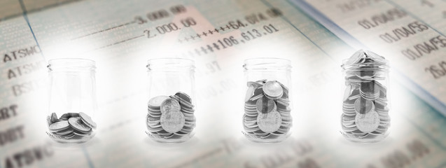 Coins in the glass with account book for finance and banking concept.