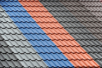 Architectural background. Texture of a metal roof tiles of black, gray, blue and red colors.
