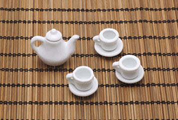 Toy cup and teapot on a napkin from a bamboo.