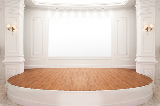 Stage of auditorium with wooden floor and white board.
