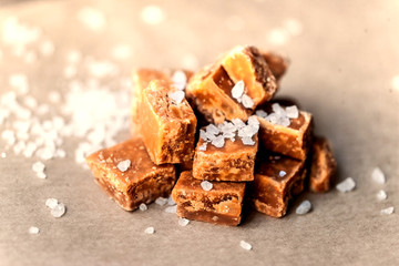Toffees. Salted caramel pieces and sea salt close up, top view.