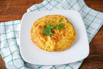 Omelet with vegetables in white ceramic plate