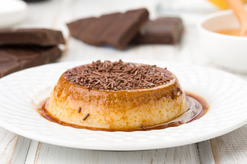 custard garnished with chocolate shavings, on wood