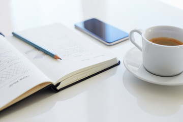 Pencil, open diary and coffee cup with sketch websites