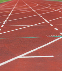 Running tracks. An image of a new running tracks in the sunshine. Grass is about to grow in the football field in the middle of the running track.
