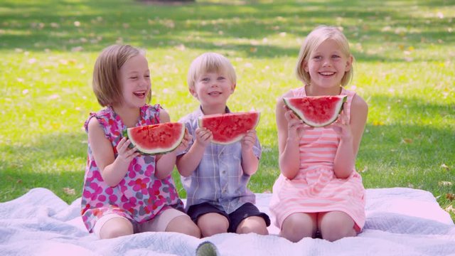 Portrait of children eating watermelon slices