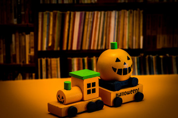 Halloween image.  Pumpkin and train on orange background.