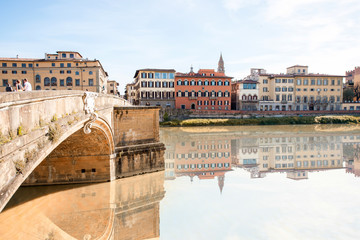 Cityscape view on the riverside with the old buildings and palaces near Holy Trinity bridge in Florence