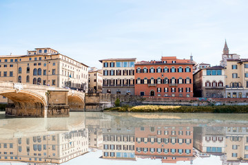 Cityscape view on the riverside with the old buildings and palaces near Holy Trinity bridge in Florence